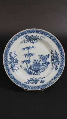 une assiette bleue et blanche ornée d'un motif