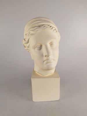 sculpture of a woman ' s head on a white base