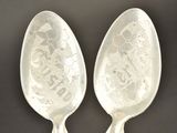 two spoons that are sitting next to each other on a table