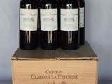 three bottles of wine are in a wooden box on a table