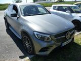 une voiture argentée garée dans un parking à côté d'autres voitures