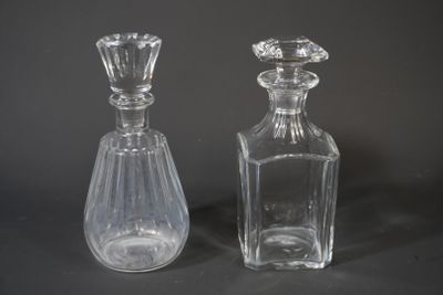 two clear glass bottles sitting next to each other on a table