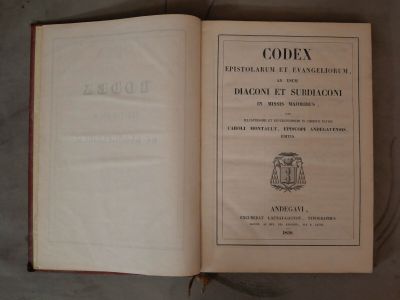 un livre ouvert sur lequel figure un blason