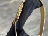 someone is holding a black purse with a gold handle