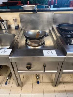 three stainless steel sinks in a kitchen with a stove top