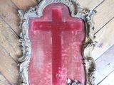 a mirror on the floor with a red cross on it