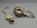 un objet en argent entouré d'une chaîne, posé sur une table
