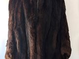 un manteau de fourrure marron posé sur un mannequin, devant un mur blanc