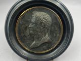 l'image d'une pièce de monnaie sur laquelle figure, au centre, le visage d'un homme