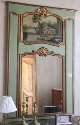 un miroir accroché au mur au-dessus d'un bureau sur lequel se trouve une lampe