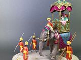 a figurine of an elephant with people around it