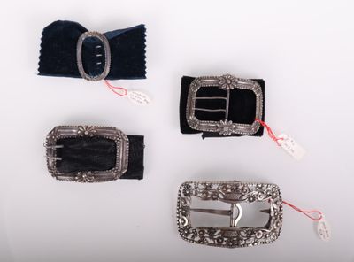 trois ceintures avec boucles argentées sur une surface blanche