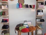 a small table with a chair and a shelf with purses on it