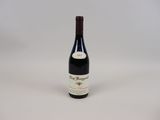 a bottle of red wine sitting on top of a white table