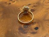 an image of a gold ring sitting on top of a wooden table