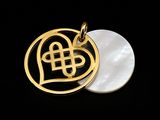 a close up of a gold pendant with a heart on it