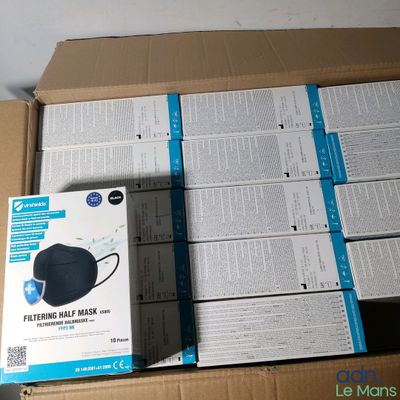 une boîte en carton sur laquelle est posé un masque noir