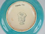 a blue and white plate with a coat of arms on it