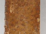 an old book sitting on top of a white surface
