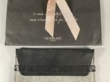 a close up of a black and white bag with a pink bow on it