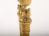 a gold vase with a bird on top of it