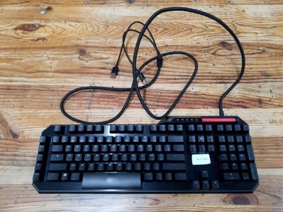 a black keyboard and a black mouse on a wooden table