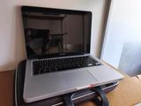 a laptop sitting on top of a suitcase on a table