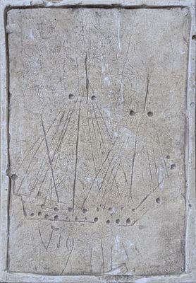 une plaque en pierre sur laquelle est représenté un bateau