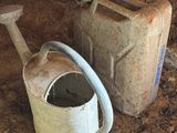 un seau et un bidon d'eau posés par terre