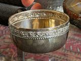 a silver bowl sitting on top of a glass table