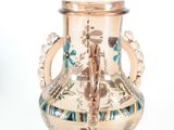 a gold vase with a blue and green design on it