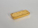 une barre d'or posée sur une surface blanche