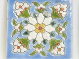 a blue and white tile with a flower design on it