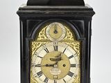une horloge noire et dorée avec des chiffres romains