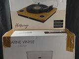 two boxes of a record player sitting on top of a wooden table