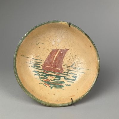 un petit bol sur lequel est peint un bateau