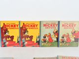 several mickey mouse books are lined up on a white surface