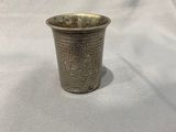 une image représentant une coupe en argent posée sur un tissu blanc