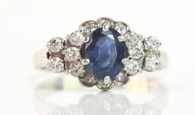 une photo d'une bague en saphir et diamants posée sur une surface blanche