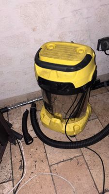 a yellow and black vacuum sitting on a tiled floor