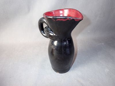 a black and red vase with a handle on a white background