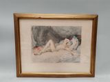 une vieille photo représentant une femme allongée sur un lit, dans un cadre doré