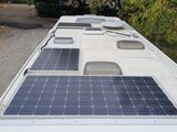 solar panels on the roof of a camper trailer parked in a lot