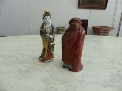two figurines sitting on a table in a room
