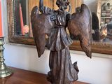a statue of an angel on a table next to a mirror