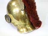 a gold helmet with a red feather on top of it