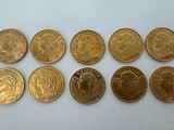 a bunch of gold coins sitting on top of a white surface