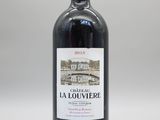 la bouteille de vin rouge est posée sur une surface blanche