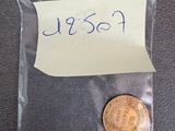 a close up of a coin in a plastic bag with a sticker on it