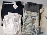 Trois paires de pantalons pour homme sont disposées sur une table.